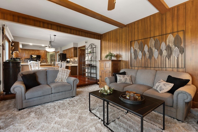16264 White Haven Dr, Northville, MI 48168 - living area featuring light colored carpet, wooden walls, ceiling fan, and beam ceiling