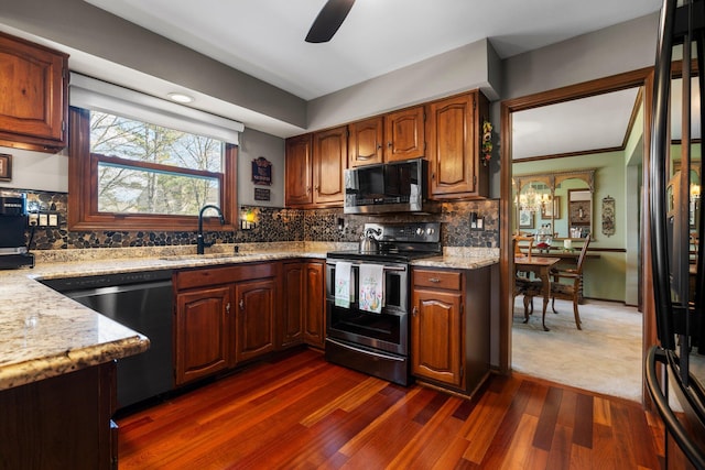 16264 White Haven Dr, Northville, MI 48168 - kitchen featuring appliances with stainless steel finishes, dark wood-style flooring, light stone counters, ceiling fan, and a sink