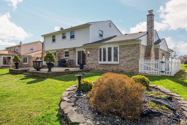 16264 White Haven Dr, Northville, MI 48168 - rear view of property featuring a lawn, a patio, fence, brick siding, and a chimney
