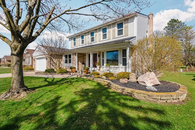 16264 White Haven Dr, Northville, MI 48168 - view of front of property with a front yard, covered porch, a garage, a chimney, and driveway