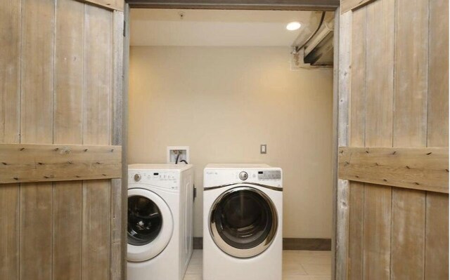 44 Lafayette Ave NE Unit 6, Grand Rapids, MI 49503 - laundry area with baseboards, light tile patterned floors, washer and clothes dryer, and laundry area
