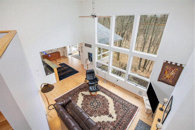8023 Trail Rdg, Dexter, MI 48130 - living area with a high ceiling, wood finished floors, and a healthy amount of sunlight