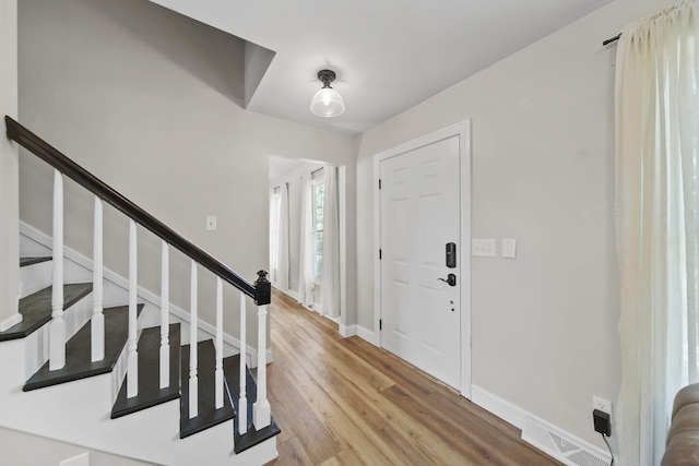 5427 Vrooman Rd, Jackson, MI 49201 - entrance foyer with baseboards, visible vents, stairs, and light wood finished floors