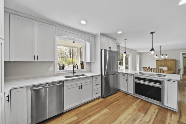 5427 Vrooman Rd, Jackson, MI 49201 - kitchen featuring a peninsula, a sink, appliances with stainless steel finishes, and light countertops