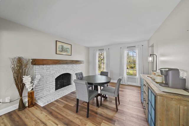 5427 Vrooman Rd, Jackson, MI 49201 - dining area with a brick fireplace, wood finished floors, and baseboards
