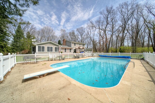 5427 Vrooman Rd, Jackson, MI 49201 - view of pool with a diving board, a patio, a fenced in pool, and fence private yard