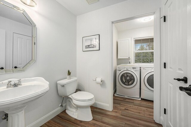 13548 Greenbriar Dr, Grand Haven, MI 49417 - half bathroom with washing machine and dryer, baseboards, toilet, and wood finished floors