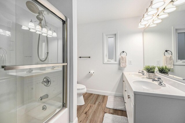 13548 Greenbriar Dr, Grand Haven, MI 49417 - bathroom with toilet, wood finished floors, a sink, and baseboards