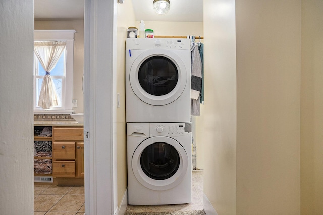 2471 Lakeshore Dr, Muskegon, MI 49441 - laundry area featuring light tile patterned floors, stacked washer / dryer, laundry area, and visible vents