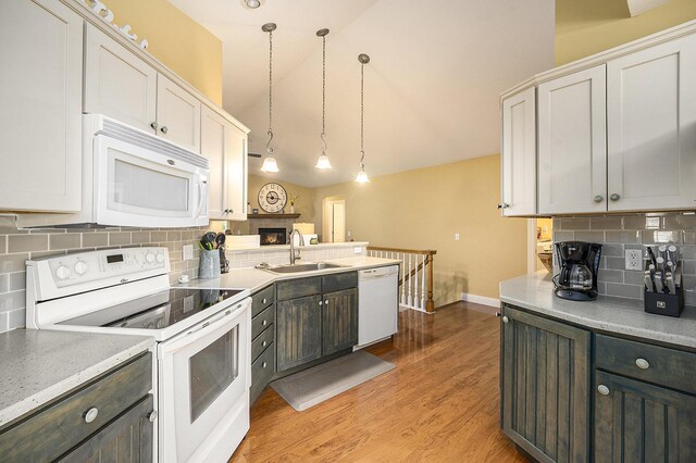 500 Mckinley, Three Rivers, MI 49093 - kitchen featuring white appliances, white cabinets, light countertops, a sink, and decorative backsplash