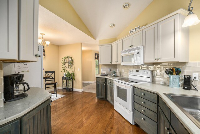 500 Mckinley, Three Rivers, MI 49093 - kitchen featuring tasteful backsplash, white appliances, decorative light fixtures, lofted ceiling, and a sink