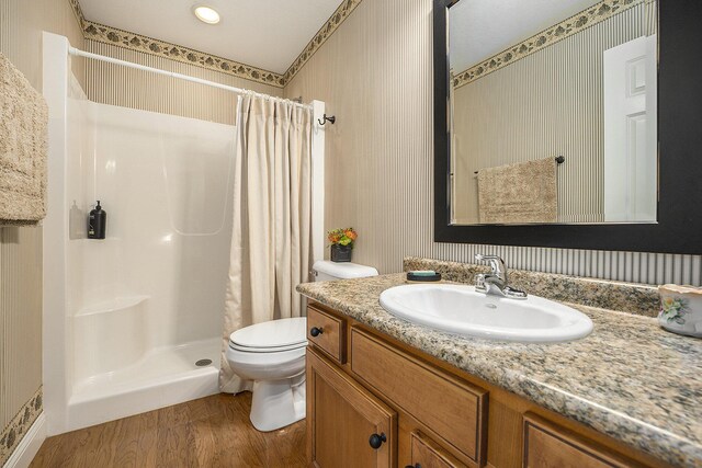 500 Mckinley, Three Rivers, MI 49093 - full bathroom featuring a shower stall, vanity, toilet, wood finished floors, and wallpapered walls