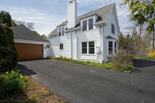 3020 Fulton St SE, Grand Rapids, MI 49506 - view of property exterior with a chimney, a garage, and a shingled roof