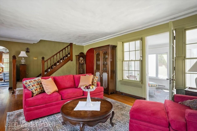 3020 Fulton St SE, Grand Rapids, MI 49506 - living area featuring arched walkways, healthy amount of natural light, wood finished floors, stairway, and crown molding
