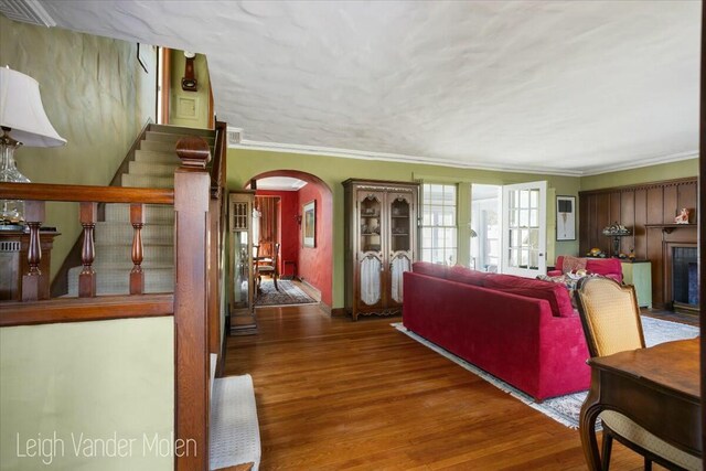 3020 Fulton St SE, Grand Rapids, MI 49506 - living area featuring arched walkways, wood finished floors, crown molding, and stairway