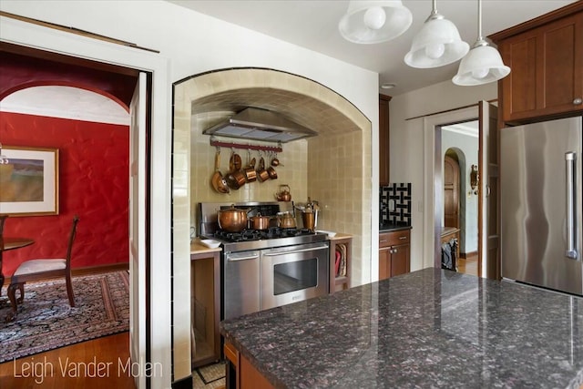 3020 Fulton St SE, Grand Rapids, MI 49506 - kitchen with stainless steel appliances, wall chimney range hood, pendant lighting, backsplash, and light wood-type flooring