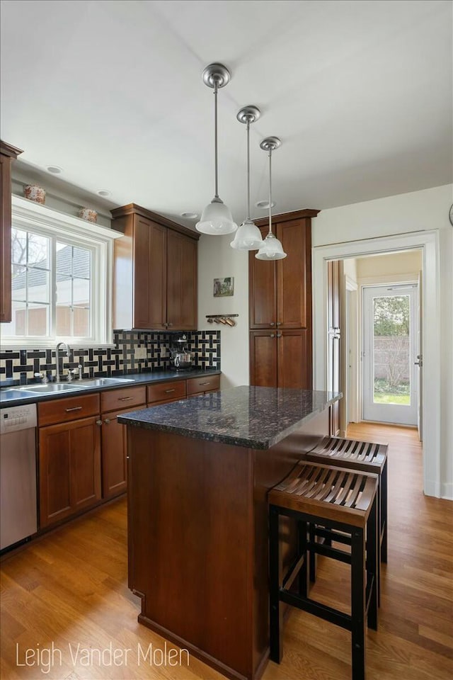 3020 Fulton St SE, Grand Rapids, MI 49506 - kitchen featuring dishwasher, a kitchen island, tasteful backsplash, a sink, and light wood-type flooring