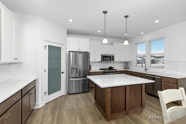 kitchen featuring tasteful backsplash, appliances with stainless steel finishes, dark wood-style floors, and white cabinets