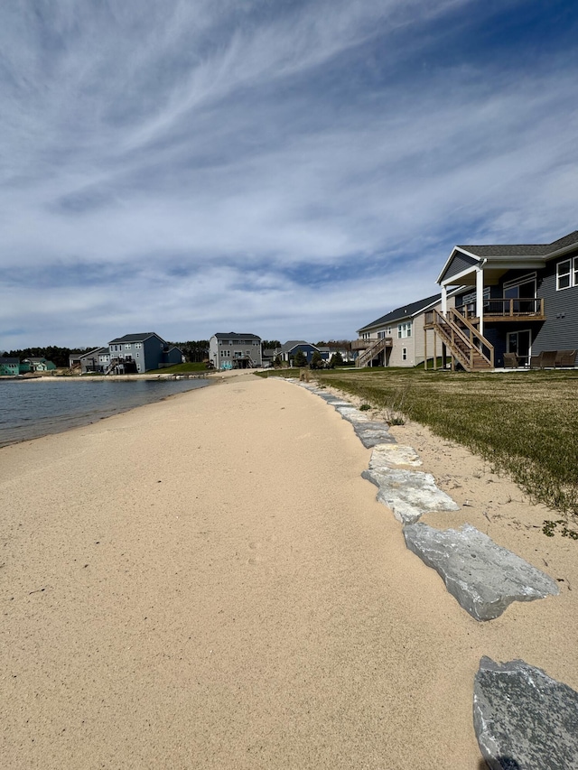 exterior space featuring a water view, stairway, and a view of the beach