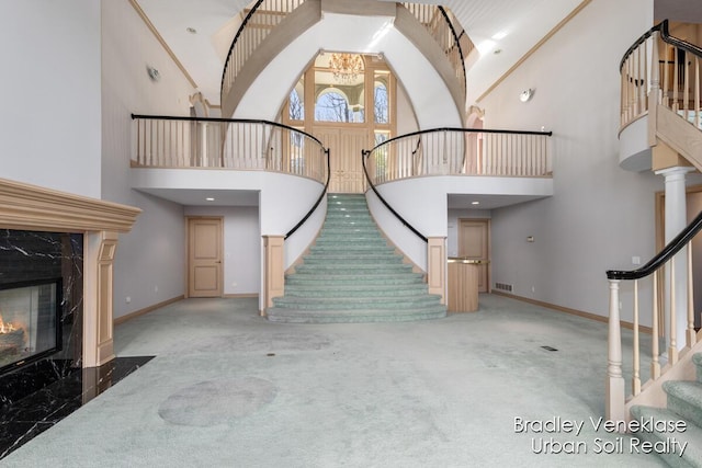 7635 Sandy Hollow Dr SE, Alto, MI 49302 - entrance foyer featuring stairway, a towering ceiling, carpet flooring, and a premium fireplace