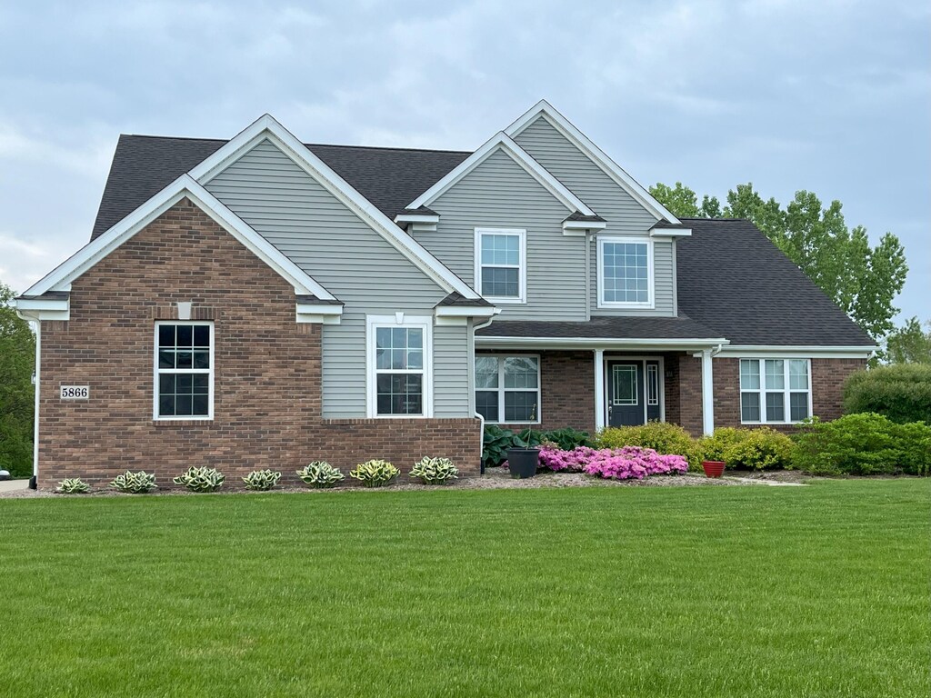 5866 Tyler Ct, Dexter, MI 48130 - craftsman-style home with brick siding and a front yard