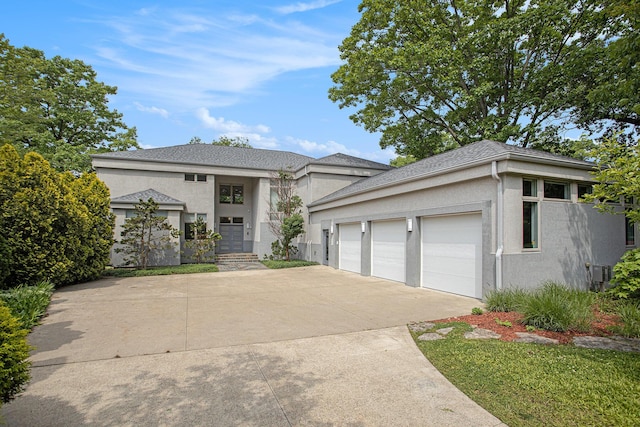 20 Hiawatha Dr, Battle Creek, MI 49015 - prairie-style house with stucco siding, concrete driveway, and an attached garage