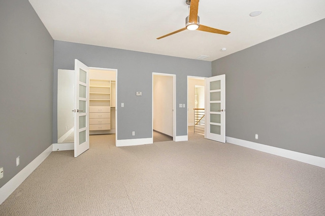 20 Hiawatha Dr, Battle Creek, MI 49015 - unfurnished bedroom with french doors, a walk in closet, light carpet, and ceiling fan