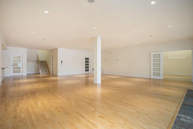 20 Hiawatha Dr, Battle Creek, MI 49015 - unfurnished living room with light wood-type flooring, stairway, and recessed lighting