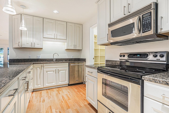 20 Hiawatha Dr, Battle Creek, MI 49015 - kitchen with stainless steel appliances, light wood finished floors, white cabinetry, dark stone counters, and recessed lighting