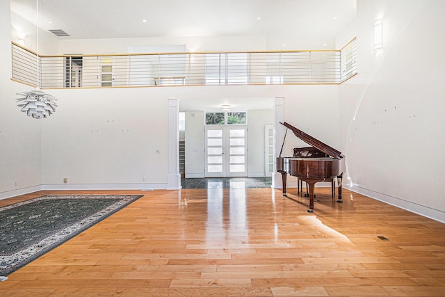 20 Hiawatha Dr, Battle Creek, MI 49015 - unfurnished living room featuring wood finished floors, a towering ceiling, and french doors