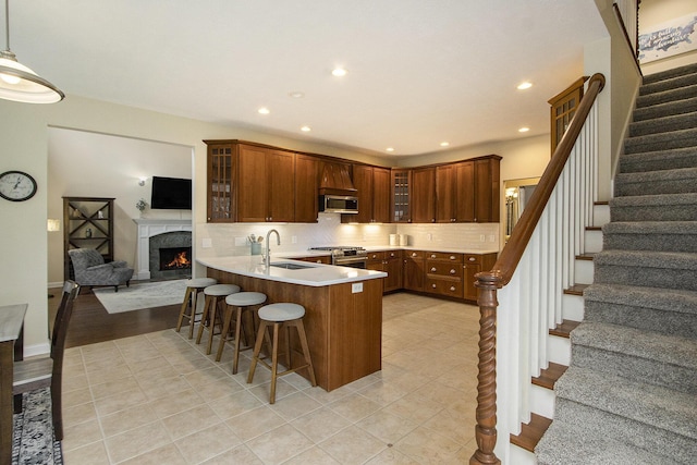 5371 S 4th St, Kalamazoo, MI 49009 - kitchen featuring appliances with stainless steel finishes, a sink, a kitchen bar, glass insert cabinets, and a peninsula