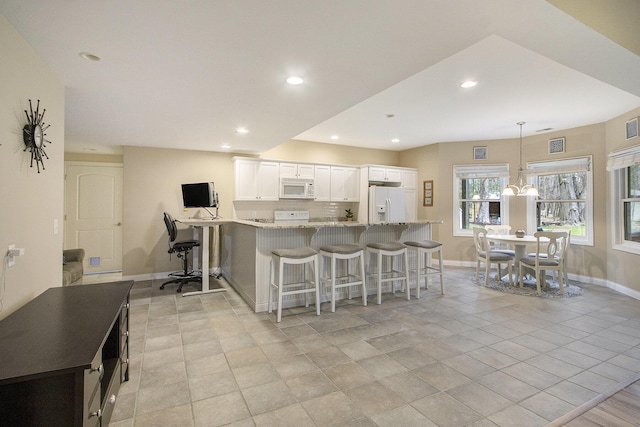 5371 S 4th St, Kalamazoo, MI 49009 - kitchen with white appliances, baseboards, a breakfast bar area, recessed lighting, and white cabinets