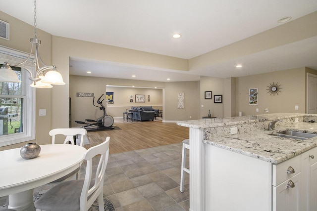 5371 S 4th St, Kalamazoo, MI 49009 - kitchen featuring a sink, recessed lighting, white cabinetry, open floor plan, and hanging light fixtures