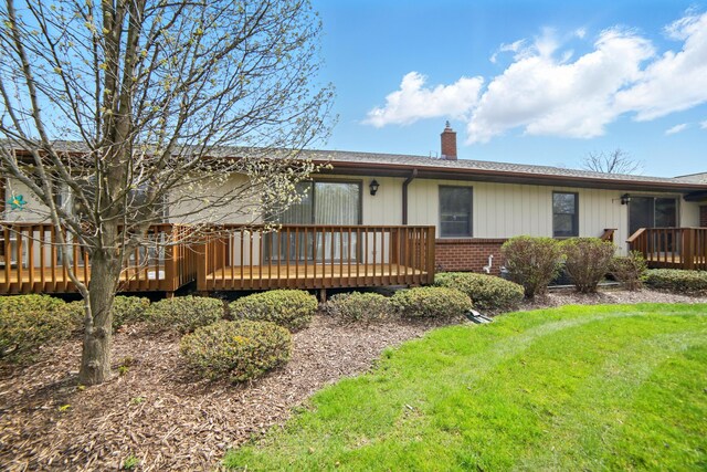256 Bona Vista Dr NW, Grand Rapids, MI 49504 - view of front of home featuring a front lawn, a chimney, brick siding, and a deck