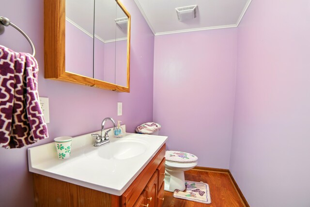 256 Bona Vista Dr NW, Grand Rapids, MI 49504 - bathroom with toilet, visible vents, wood finished floors, vanity, and ornamental molding