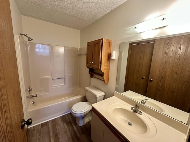 1049 Leroux Rd, Muskegon, MI 49441 - bathroom featuring a textured ceiling, wood finished floors, vanity, toilet, and bathing tub / shower combination