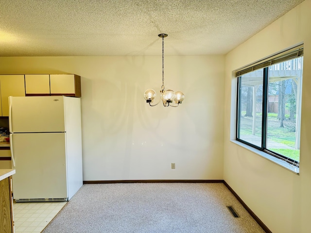 1049 Leroux Rd, Muskegon, MI 49441 - unfurnished dining area with light carpet, a chandelier, a textured ceiling, and visible vents