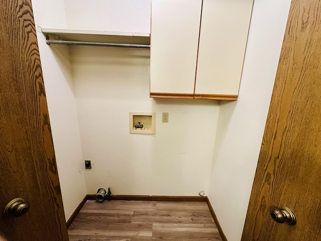 1049 Leroux Rd, Muskegon, MI 49441 - laundry room with cabinet space, hookup for a washing machine, baseboards, wood finished floors, and hookup for an electric dryer