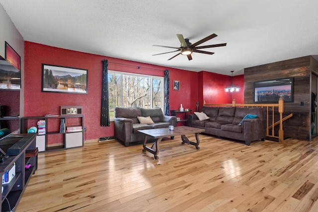 8524 E B Ave, Richland, MI 49083 - living room featuring hardwood / wood-style flooring, a ceiling fan, an accent wall, a textured wall, and a textured ceiling