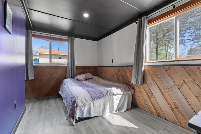 8524 E B Ave, Richland, MI 49083 - bedroom featuring a wainscoted wall, wooden walls, multiple windows, and wood finished floors