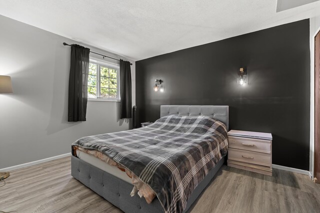 8524 E B Ave, Richland, MI 49083 - bedroom with wood finished floors, baseboards, and a textured ceiling