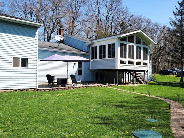 8524 E B Ave, Richland, MI 49083 - back of property with a sunroom, a yard, a chimney, a patio area, and stairs