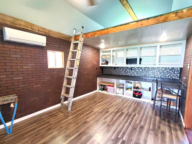 8524 E B Ave, Richland, MI 49083 - bar with a wall mounted AC, brick wall, wood finished floors, and vaulted ceiling