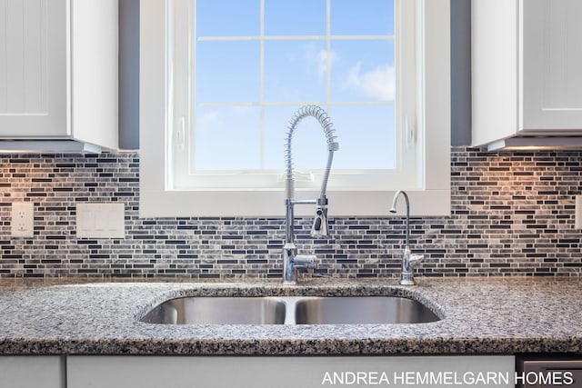 4459 36th St, Hamilton, MI 49419 - interior details with white cabinets, a sink, dark stone counters, and tasteful backsplash