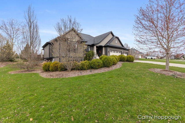 view of side of home with an attached garage, a yard, and concrete driveway