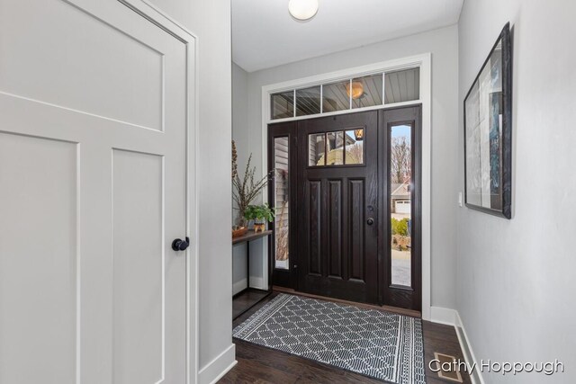foyer entrance featuring baseboards and dark wood-style floors