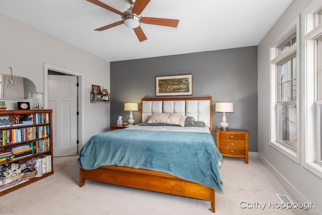 bedroom with carpet floors, a ceiling fan, and multiple windows