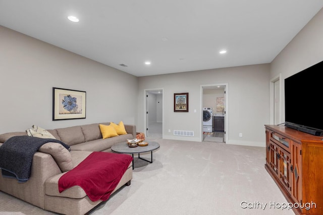 living area with visible vents, recessed lighting, light colored carpet, and washer / dryer