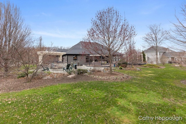 rear view of house featuring a lawn and a patio