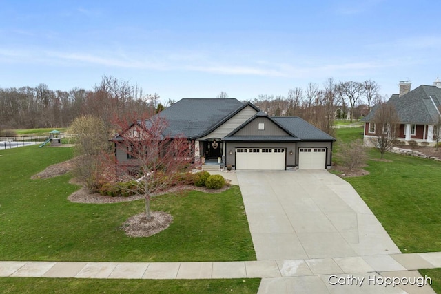 view of front of home with a garage, driveway, a front lawn, and a playground